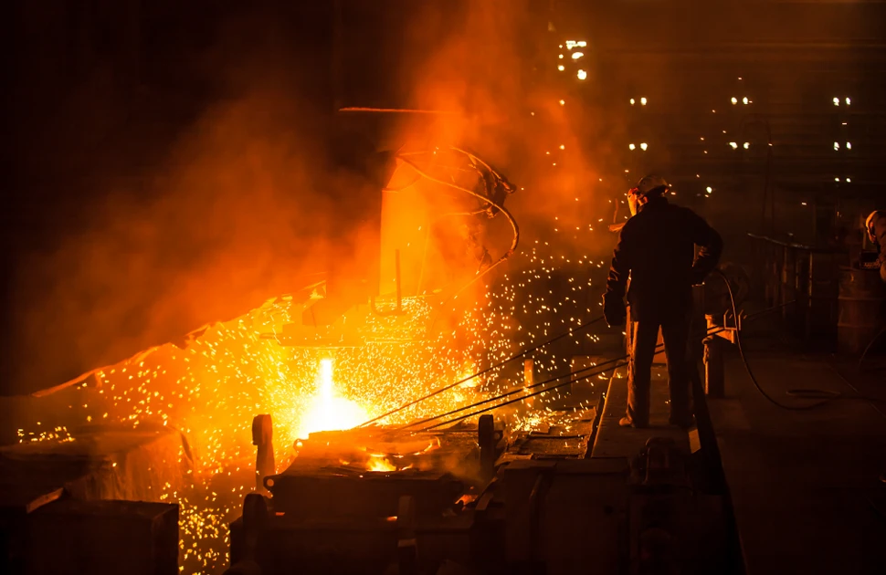 A steelworker working at an electric arc furnace