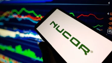 Nucor logo in front of price movement charts