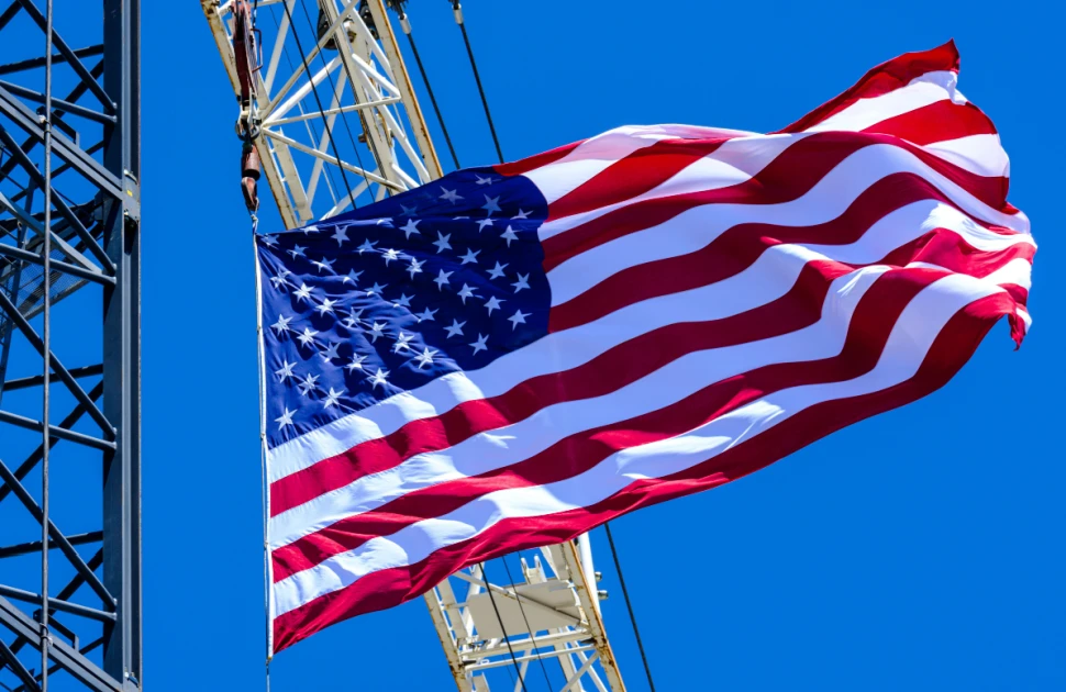 A construction site crane flying a United States flag