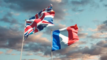 UK's Union Jack and French Tricolor blowing in the wind