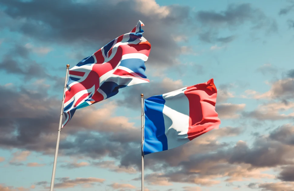 UK's Union Jack and French Tricolor blowing in the wind