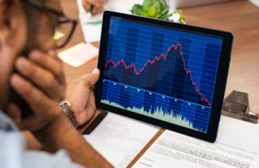 Businessman views chart showing downward trend