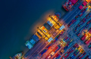 Cargo ship being unloaded in a port at night