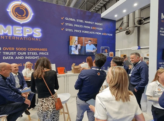 People networking at the MEPS International booth during a trade event.