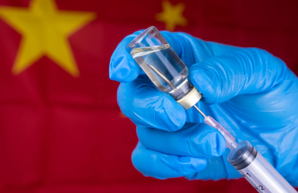 Coronavirus (COVID 19) Vaccine and syringe injection hand hold Doctor or nurse on flag China background.