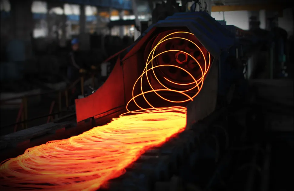 Red hot steel metal wire rods or coils after molten steel casting. Continuous casting machine. Background of the blacksmith and metallurgical industry.
